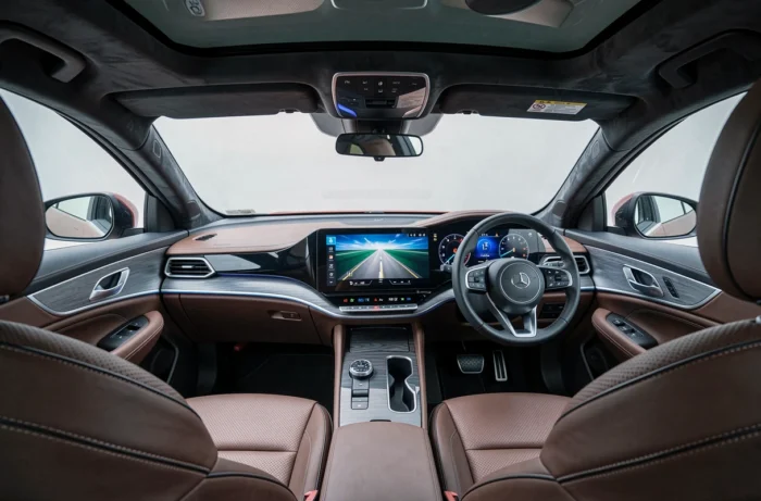 Intérieur cockpit d'un véhicule hybride de luxe 2024 avec tableau de bord numérique courbe et sièges en cuir perforé